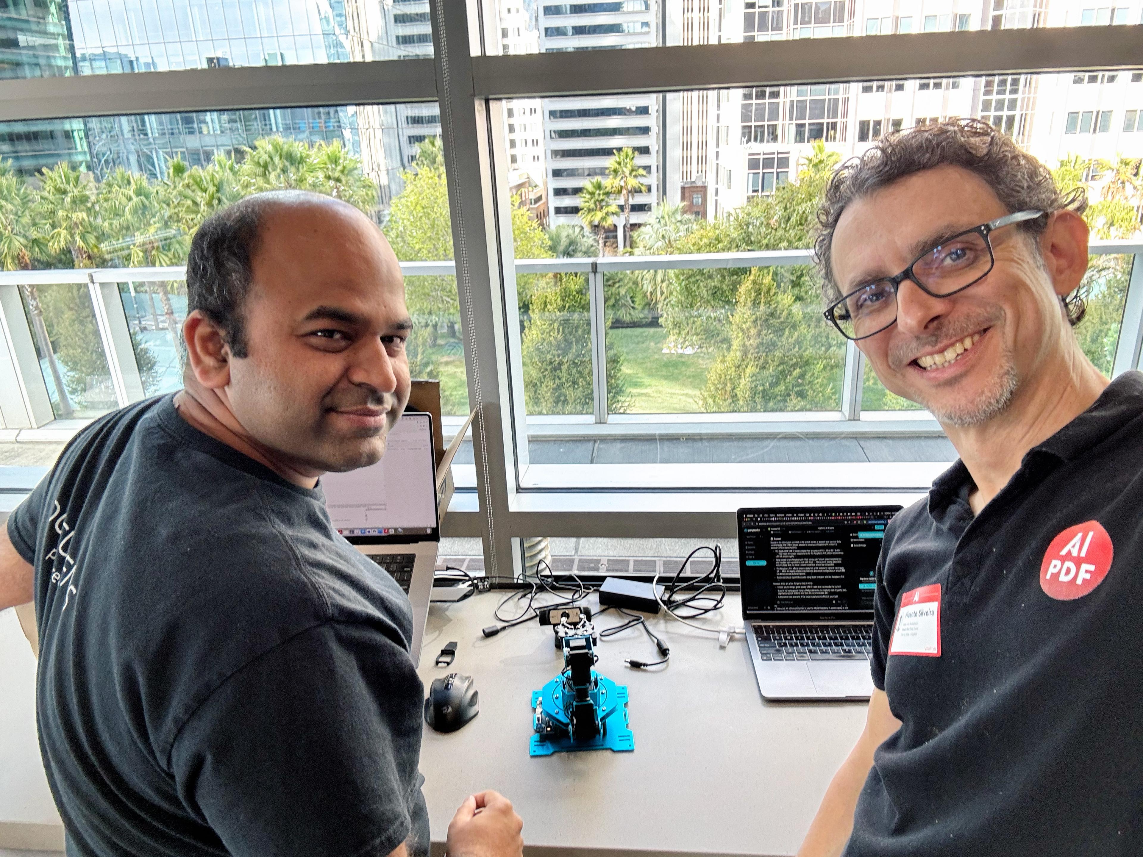 Two people working with a robotic arm